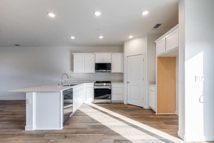 A kitchen with white cabinets.