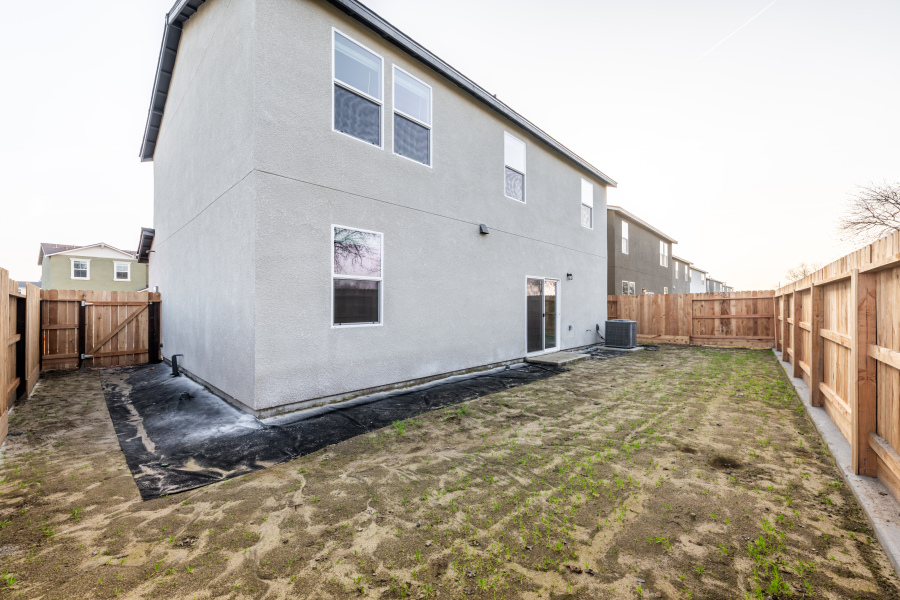 A grey house with a fence around it.