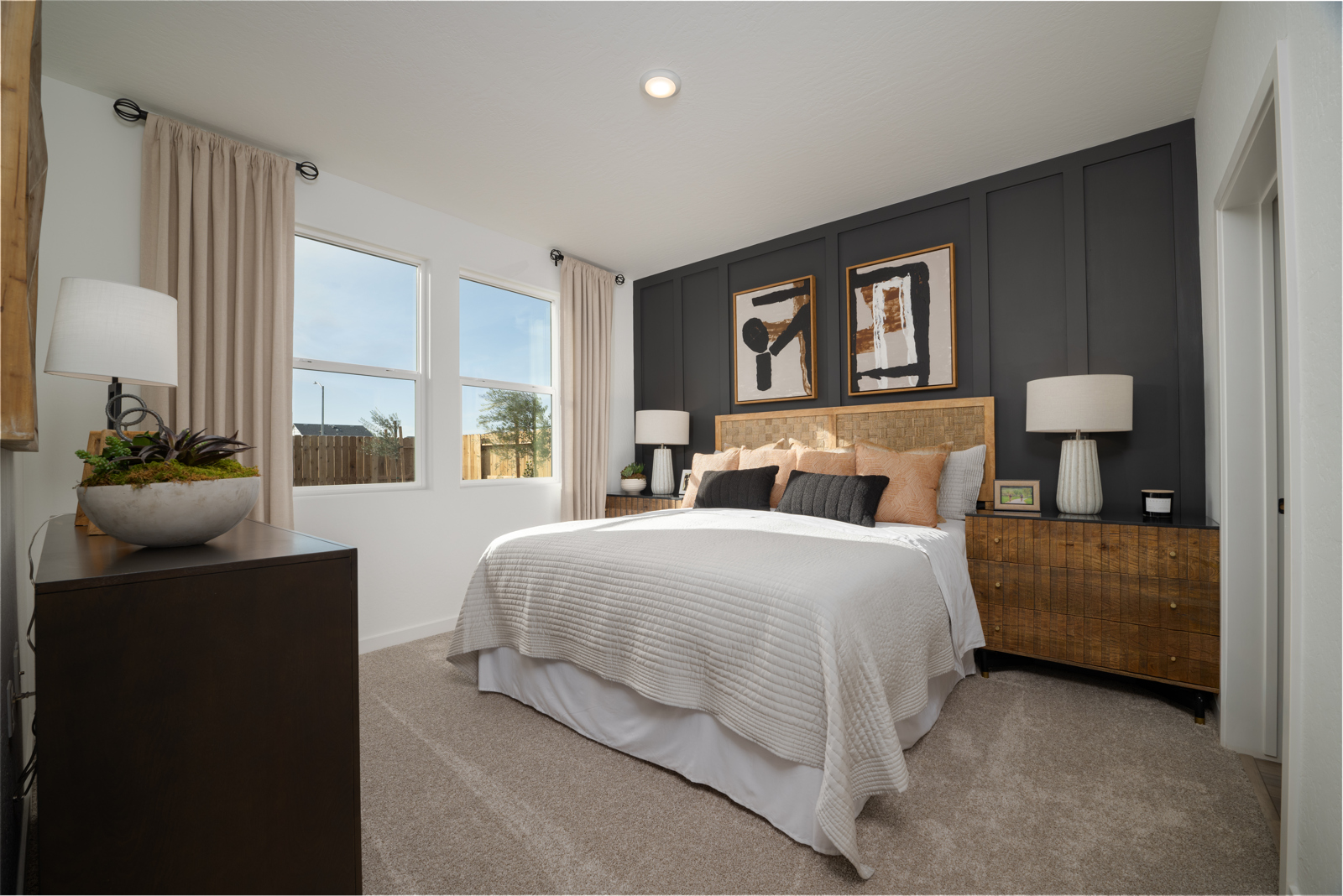 A bedroom with a bed and lamps.