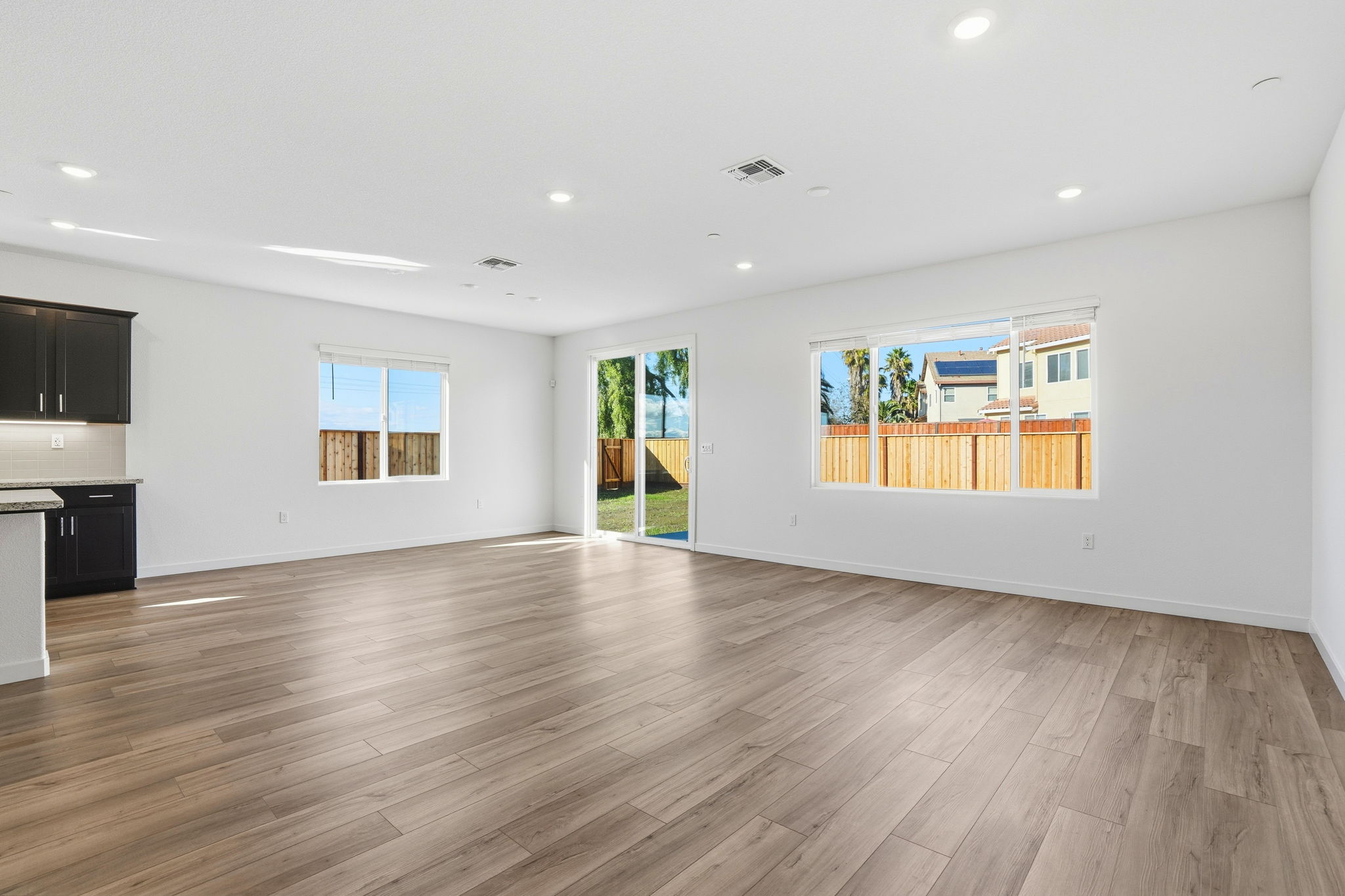 A large empty room with a wood floor and a large painting on the wall.