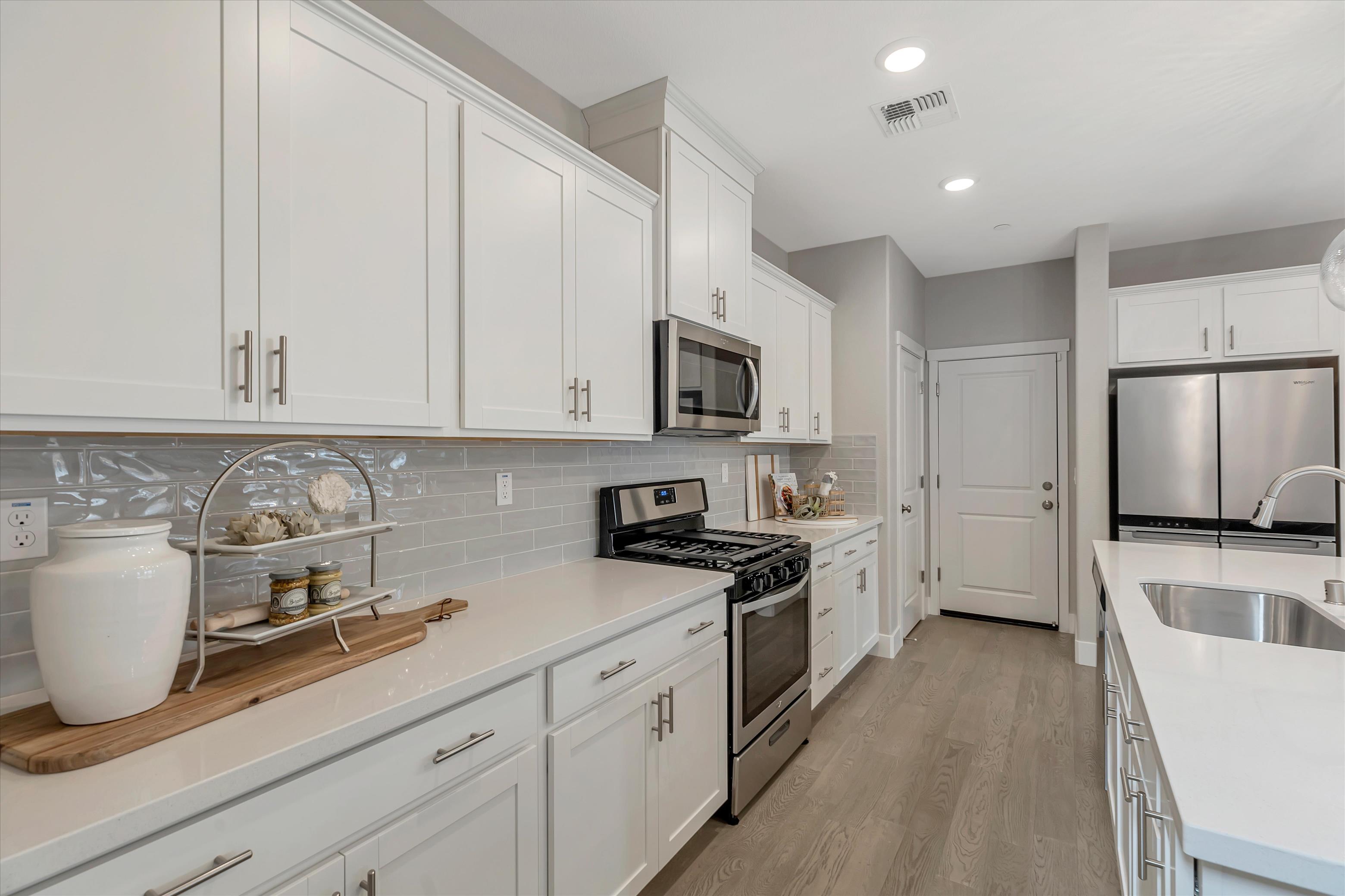A kitchen with white cabinets.