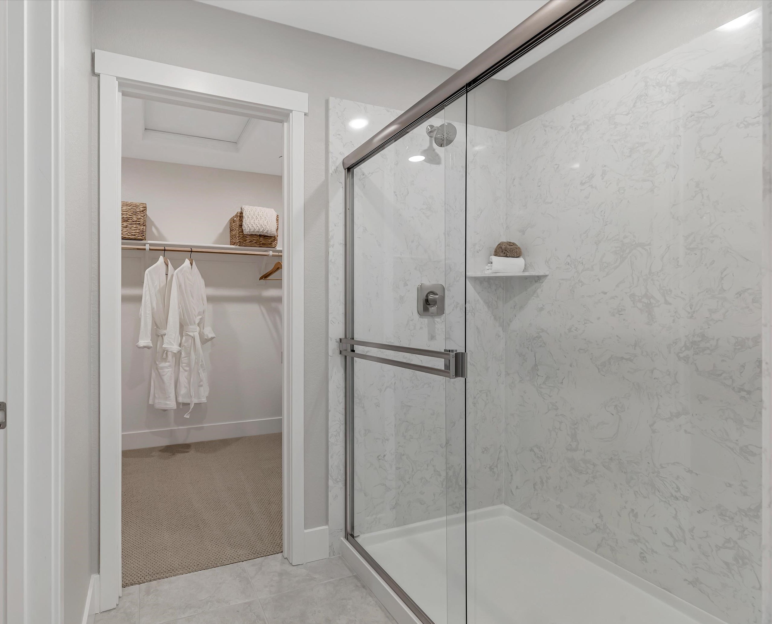 A bathroom with a shower unit and a glass door.