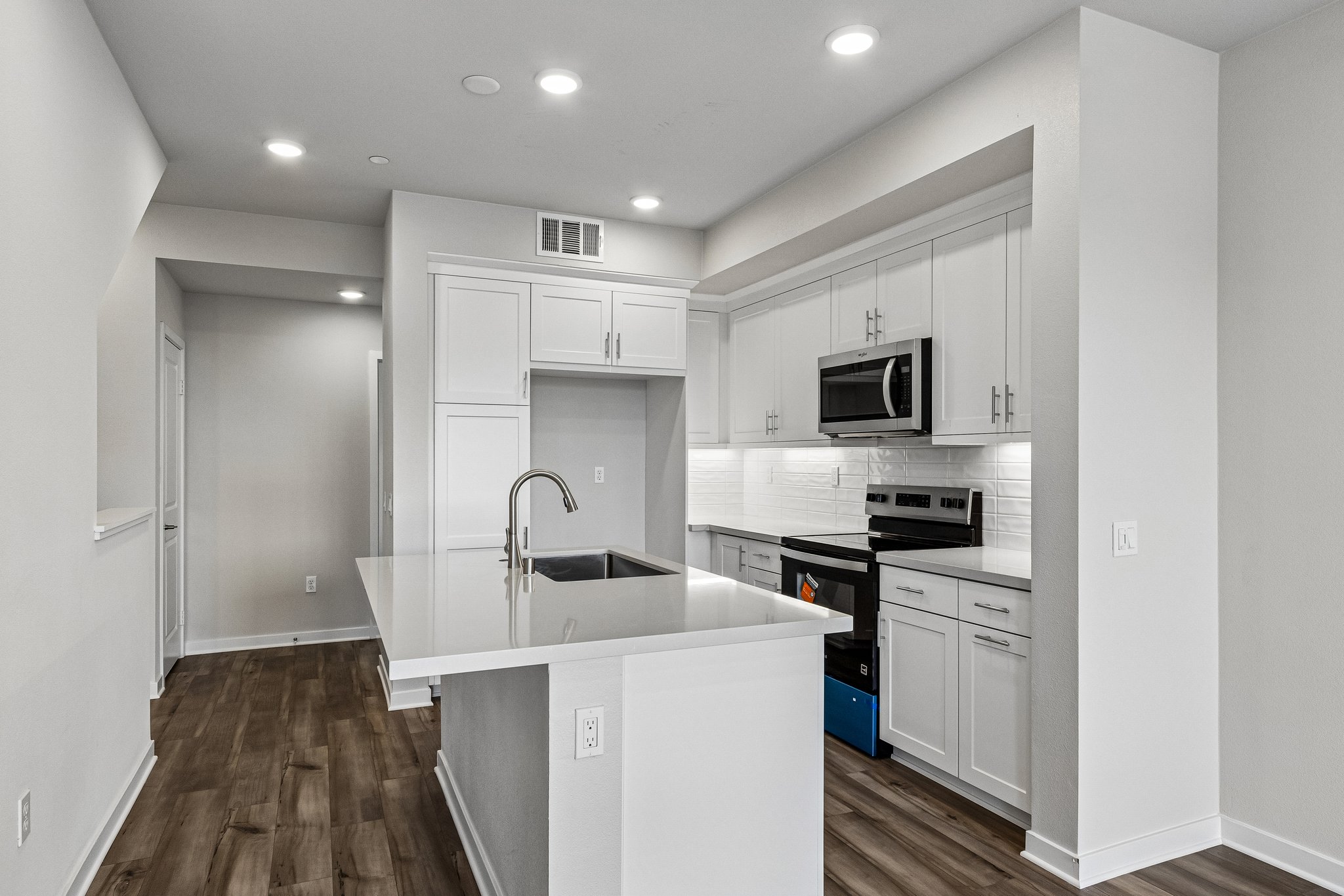 A kitchen with white cabinets.