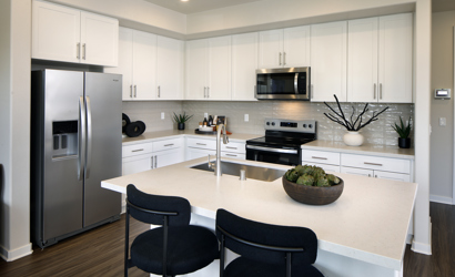 A kitchen with white cabinets.
