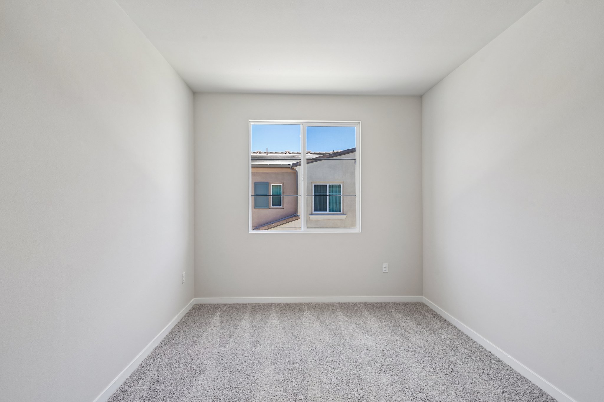 A room with a window and a rug.