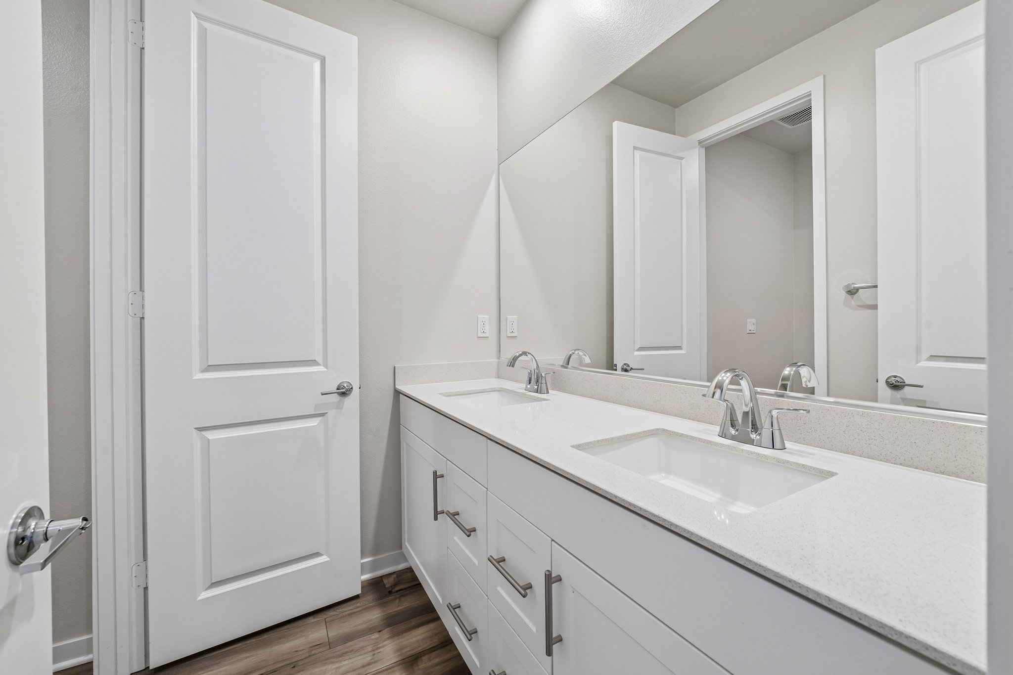A bathroom with white cabinets.