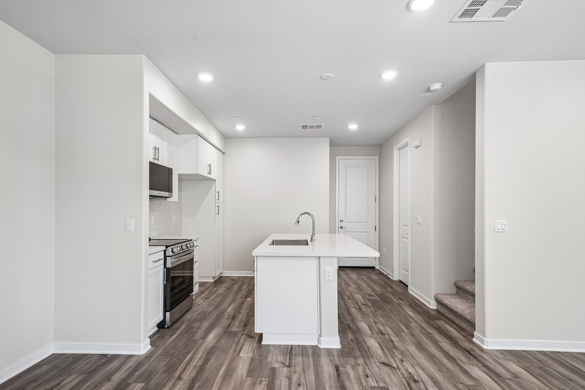 A kitchen with white cabinets.