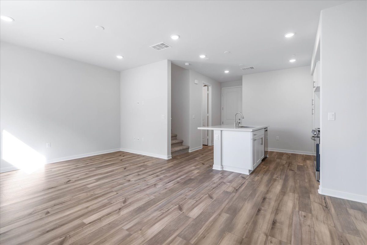 A room with white cabinets and a wood floor.