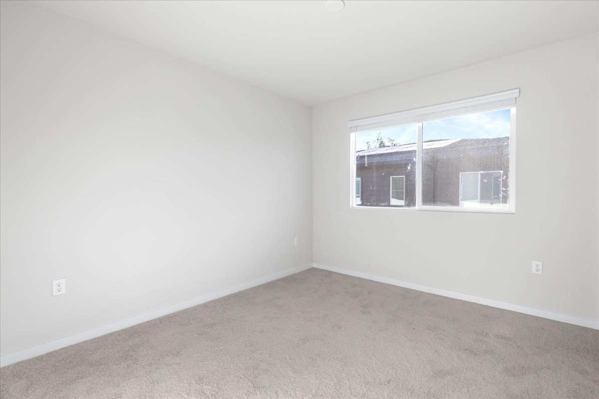 A room with a window and a carpet.