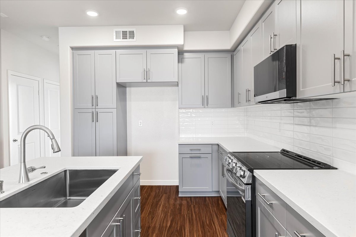 A kitchen with white cabinets.