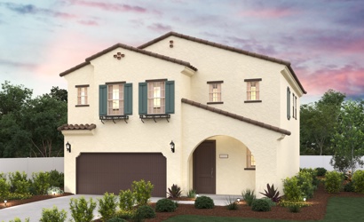A house with a garage and bushes in front of it.