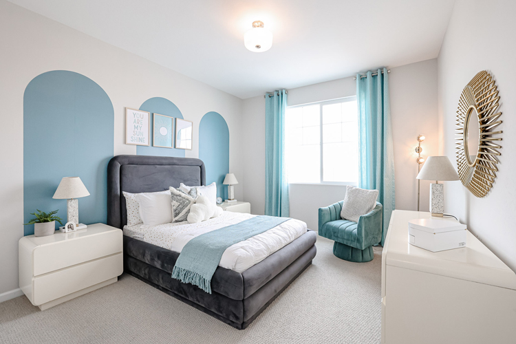 A bedroom with a bed and a chair.