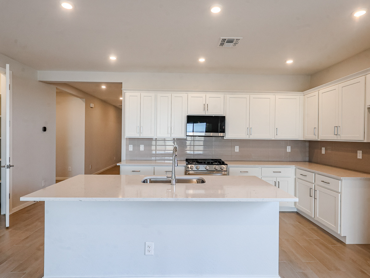 A kitchen with white cabinets.