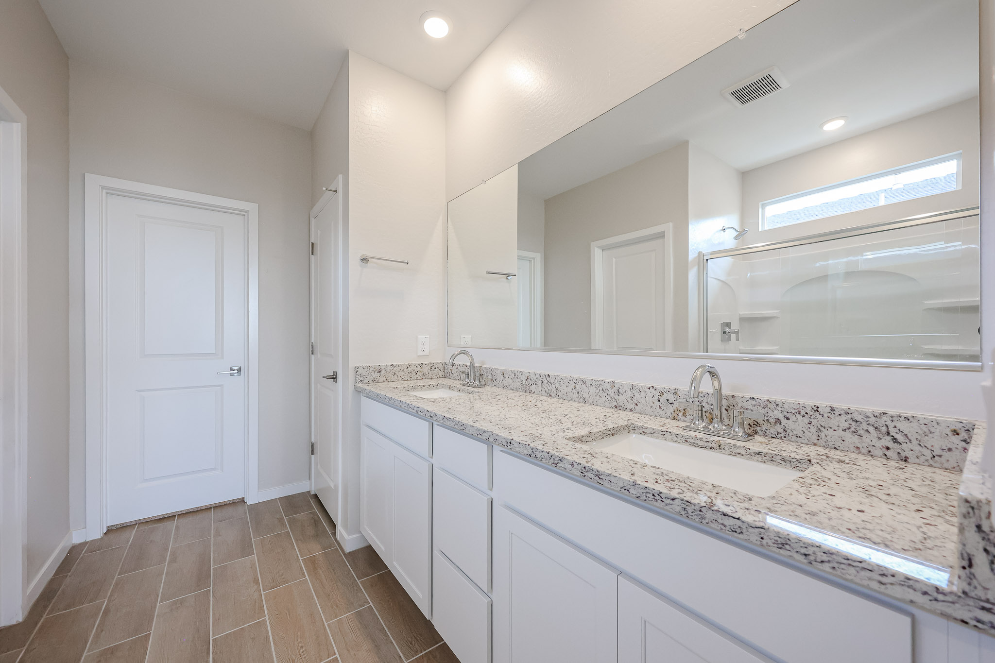 A bathroom with a large mirror.