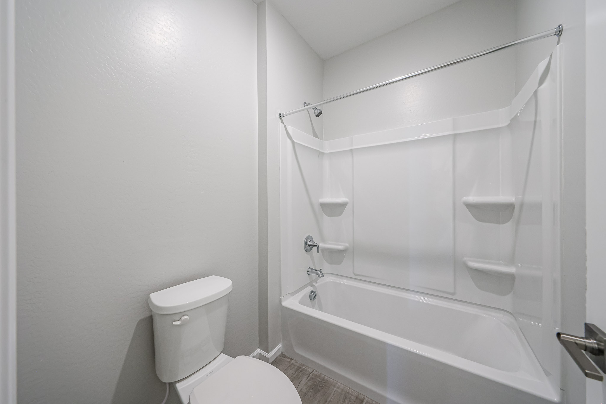 A bathroom with a shower and toilet.