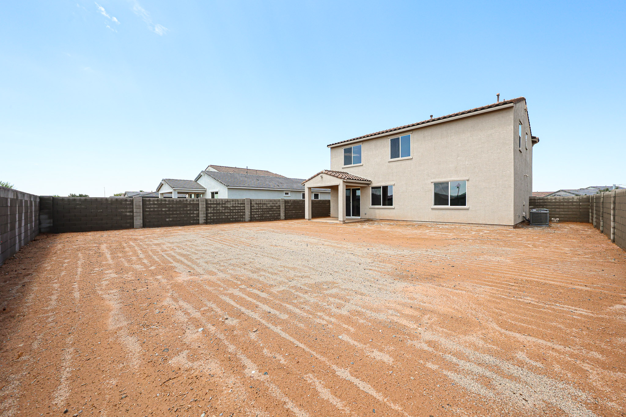 A dirt road leading to a house.