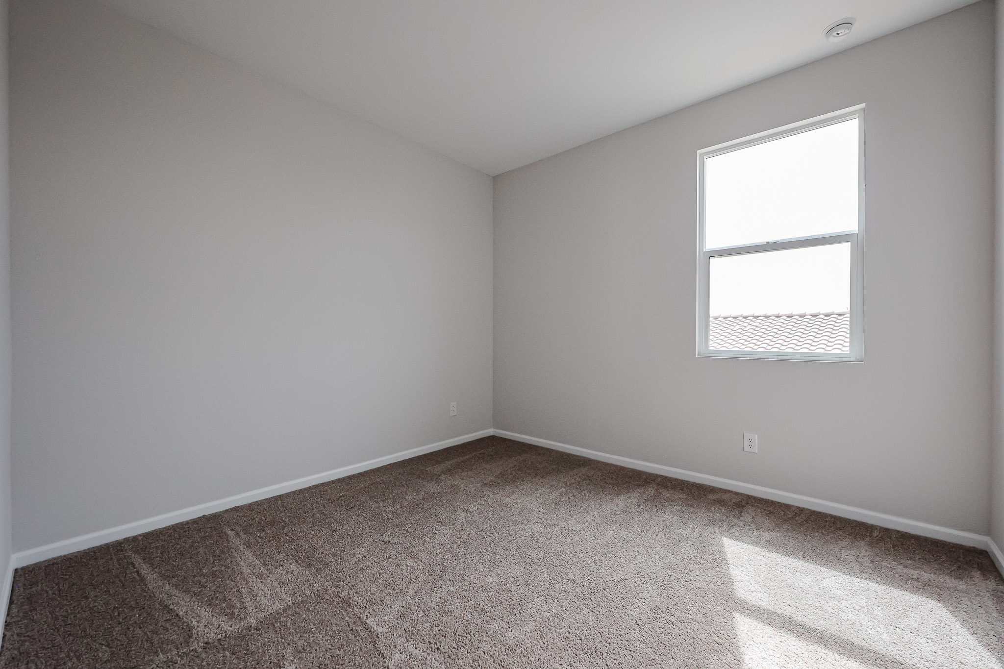 A room with a window and carpet.