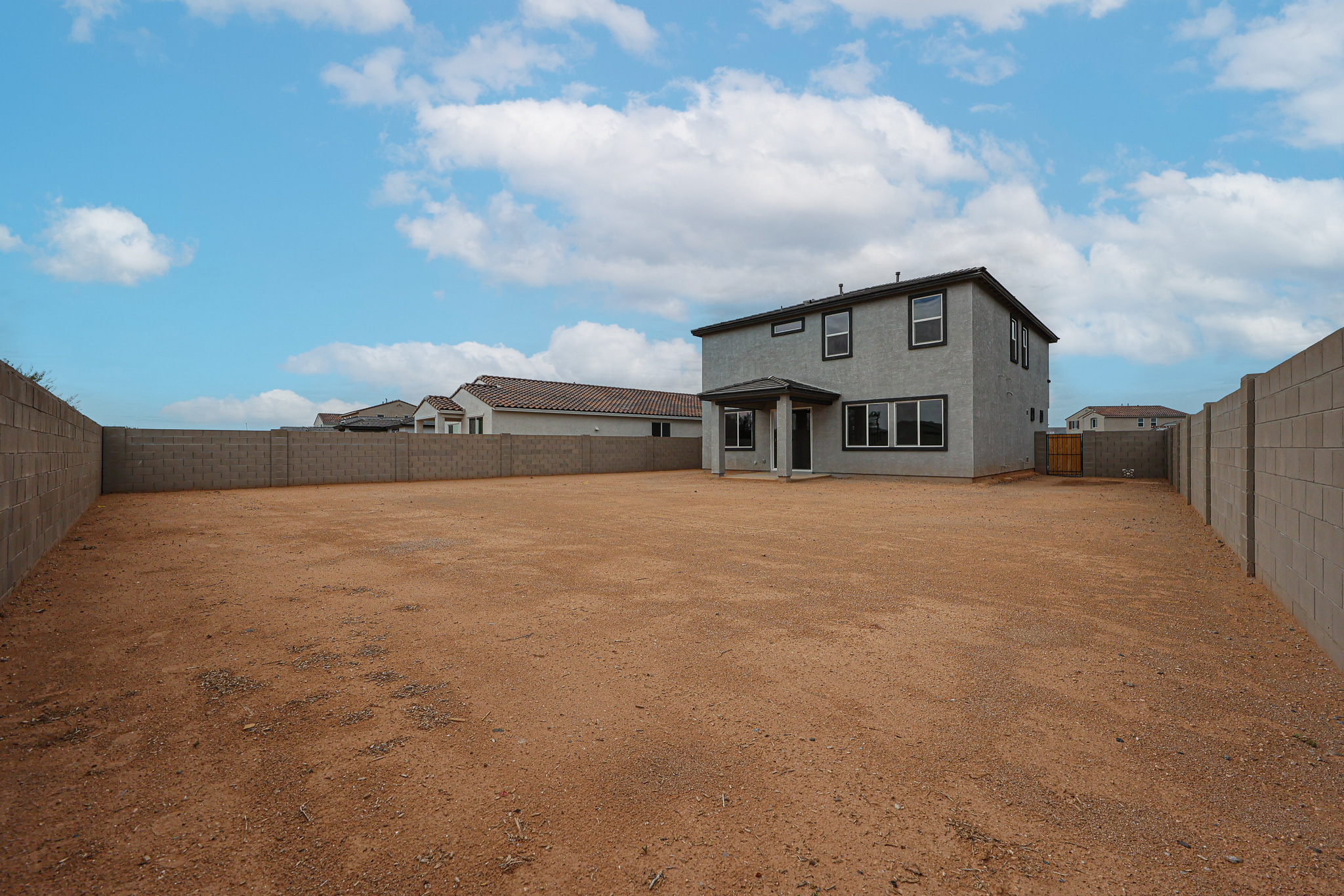 A dirt field with buildings in the background.