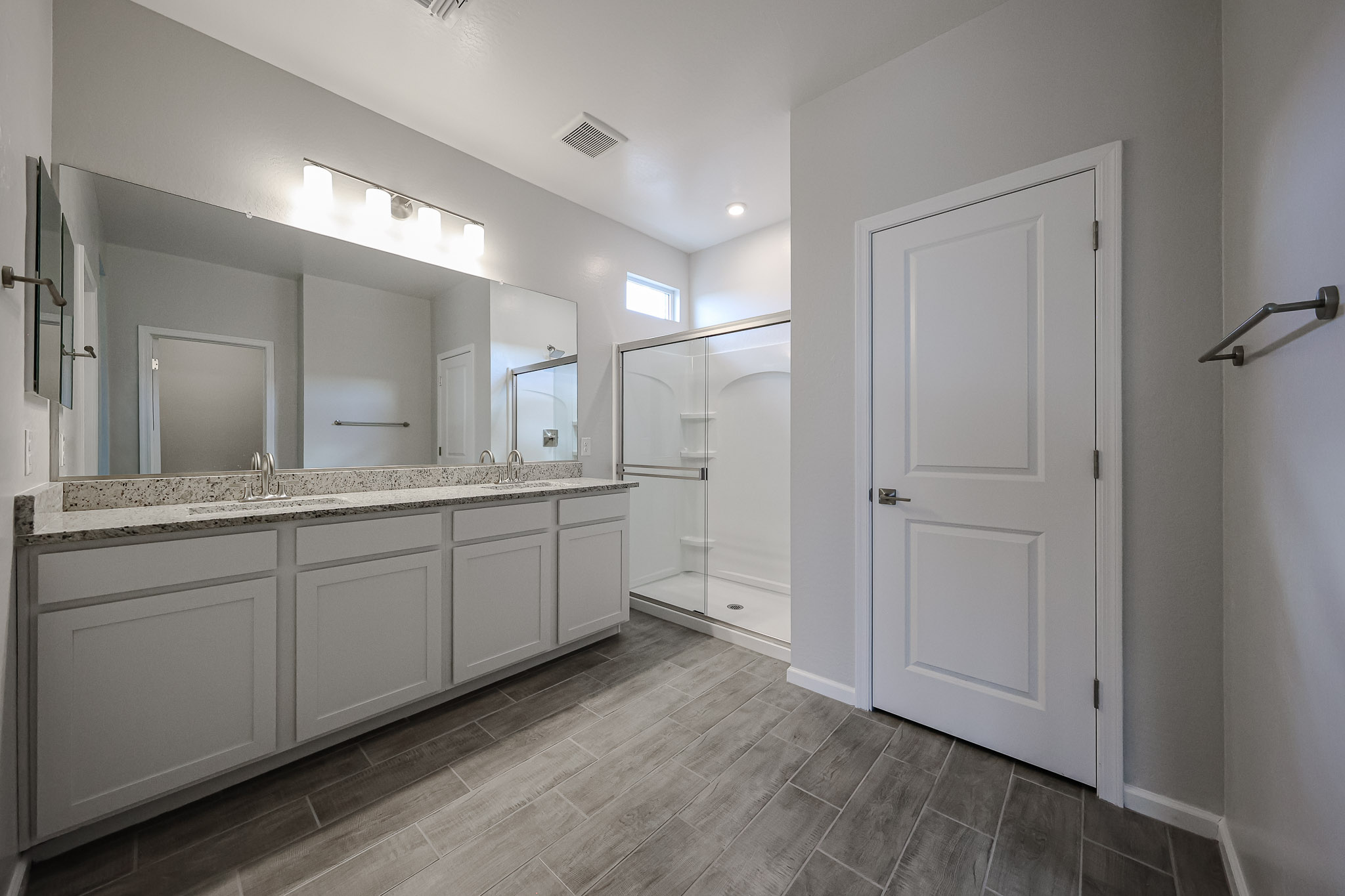 A bathroom with white cabinets.
