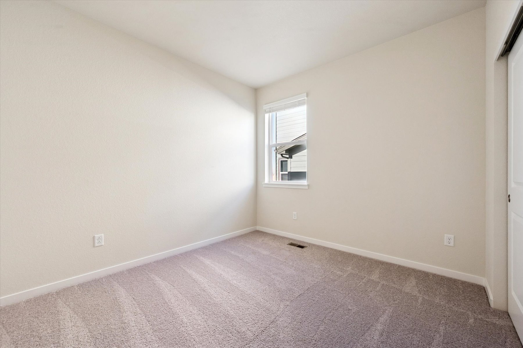 A room with a carpet and a window.