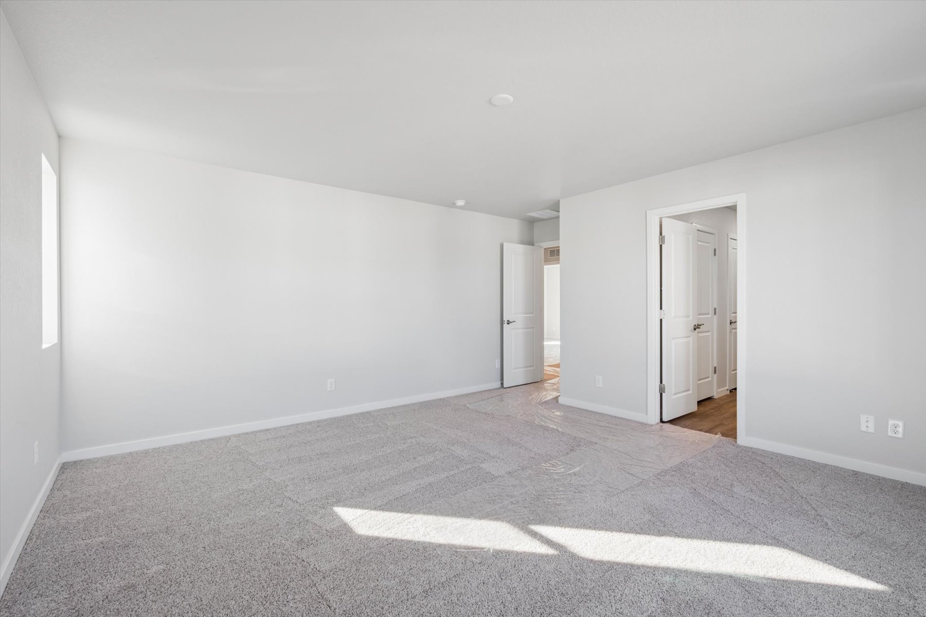 A long hallway with white doors.