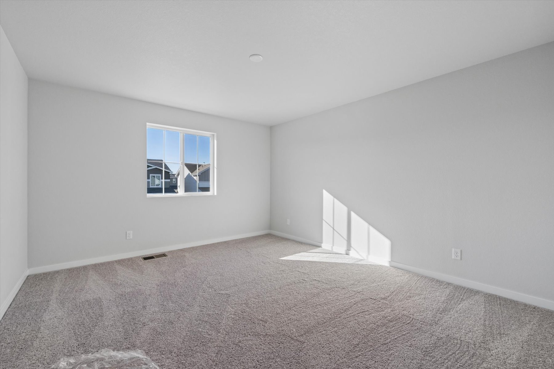 A room with a window and carpet.