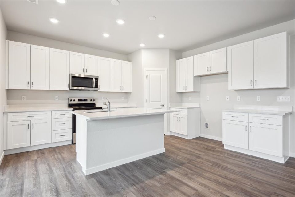A kitchen with white cabinets.