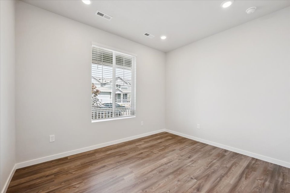 A room with a wood floor and a window.