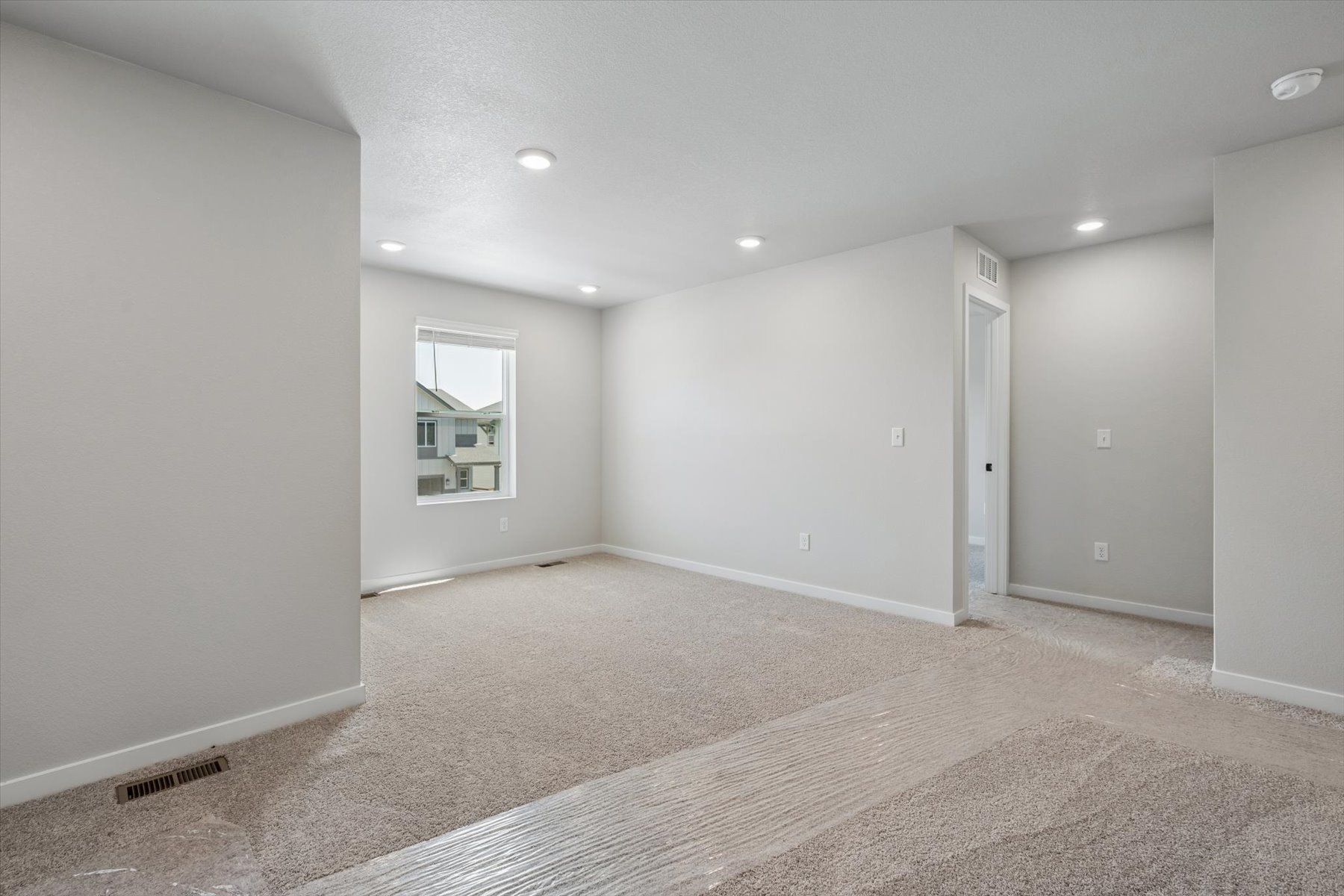 A room with a carpet and a window.