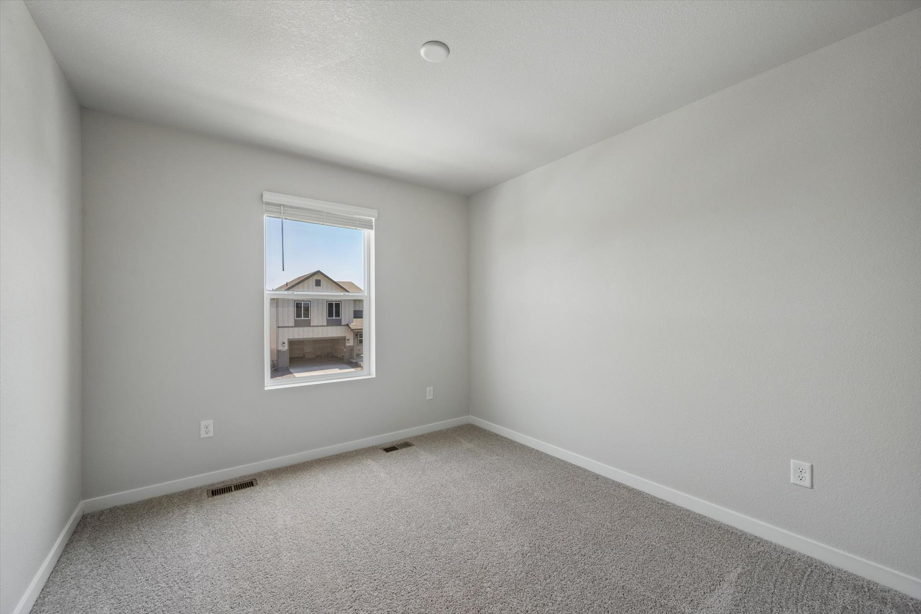 A room with a window and a carpet.