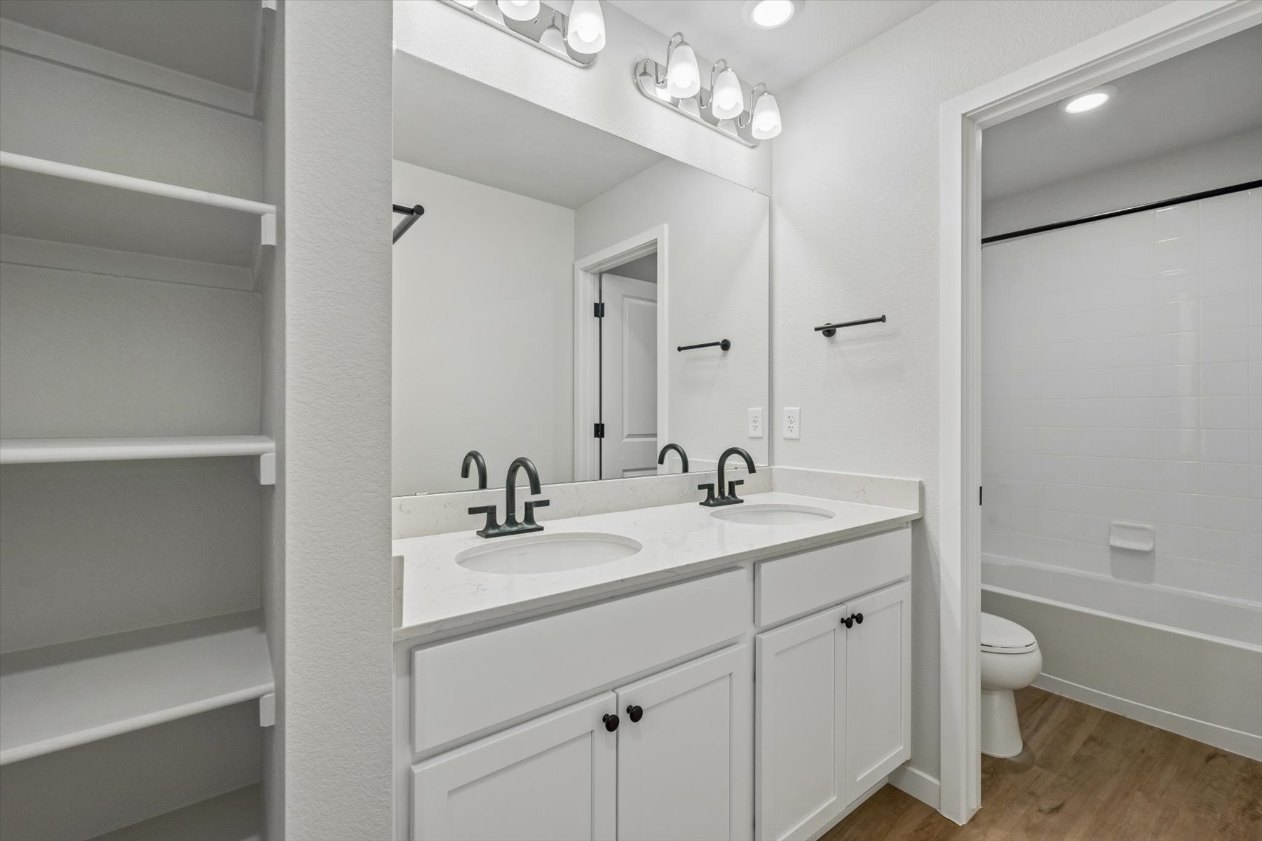 A bathroom with a sink toilet and mirror.