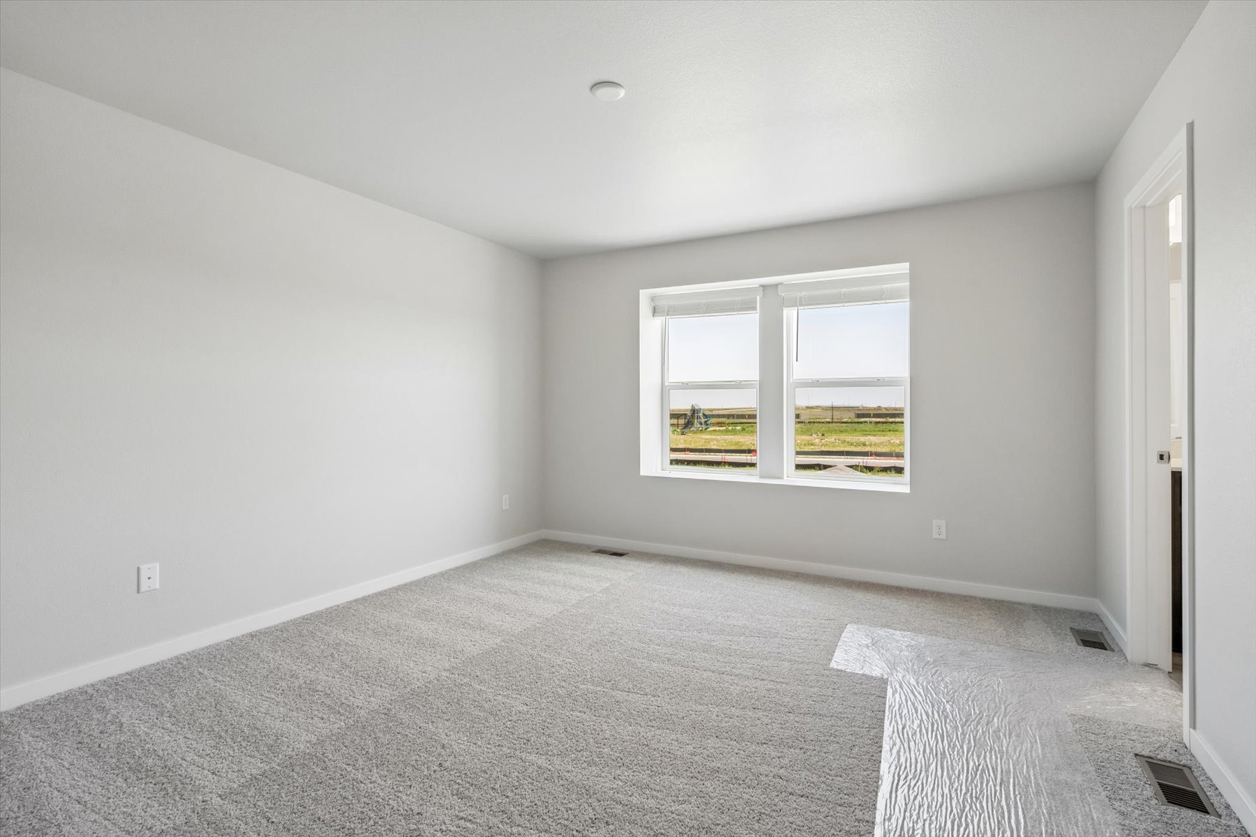 A room with a window and a rug.