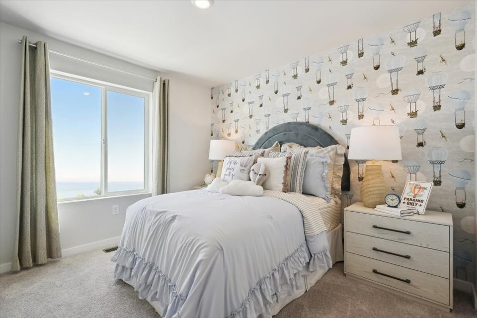 A bedroom with a bed and lamps.