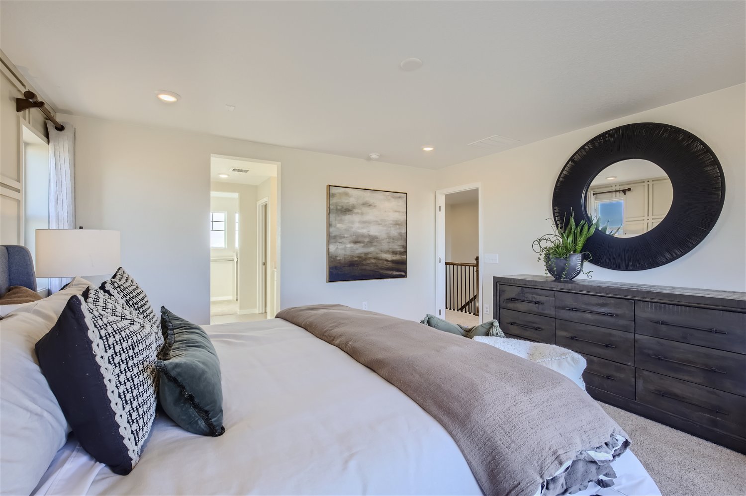 A bedroom with a large mirror.