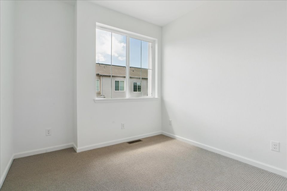 A room with a window and a carpet.