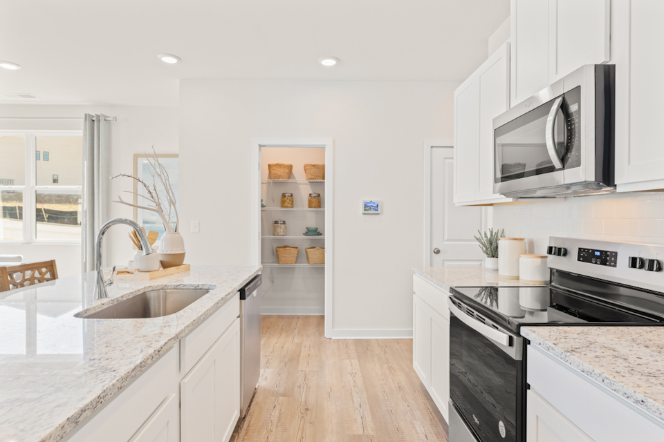 A kitchen with white cabinets.