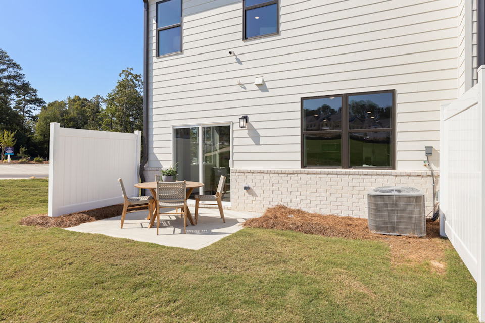 A backyard with a table and chairs.