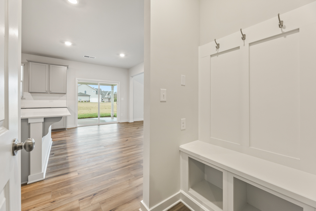 A white kitchen with a wood floor.