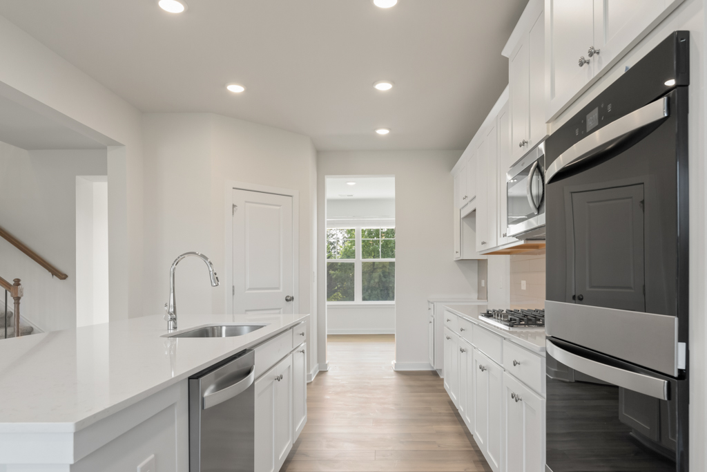 A kitchen with white cabinets.