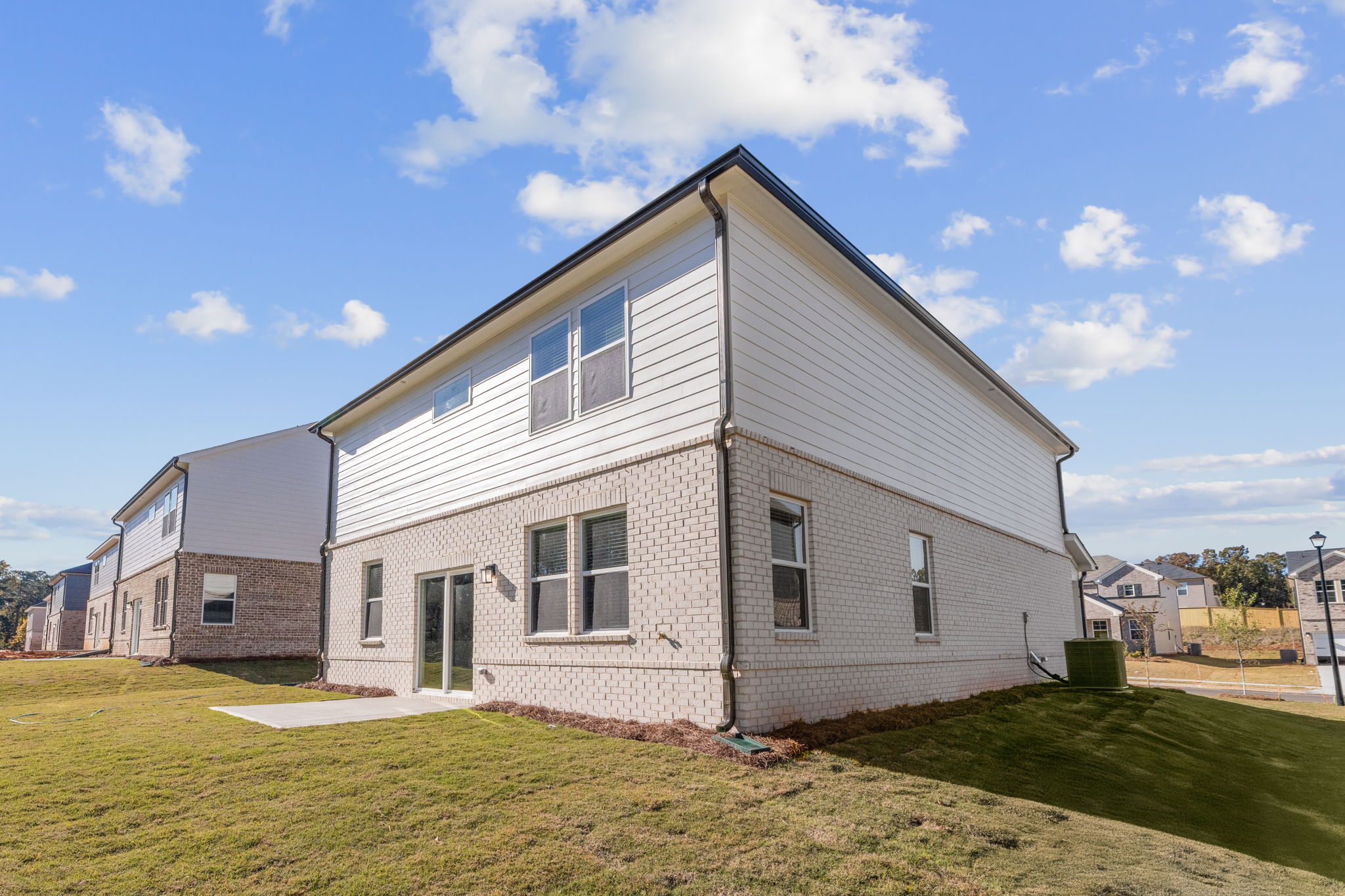 A house with a yard with Rockingham Meeting House in the background.