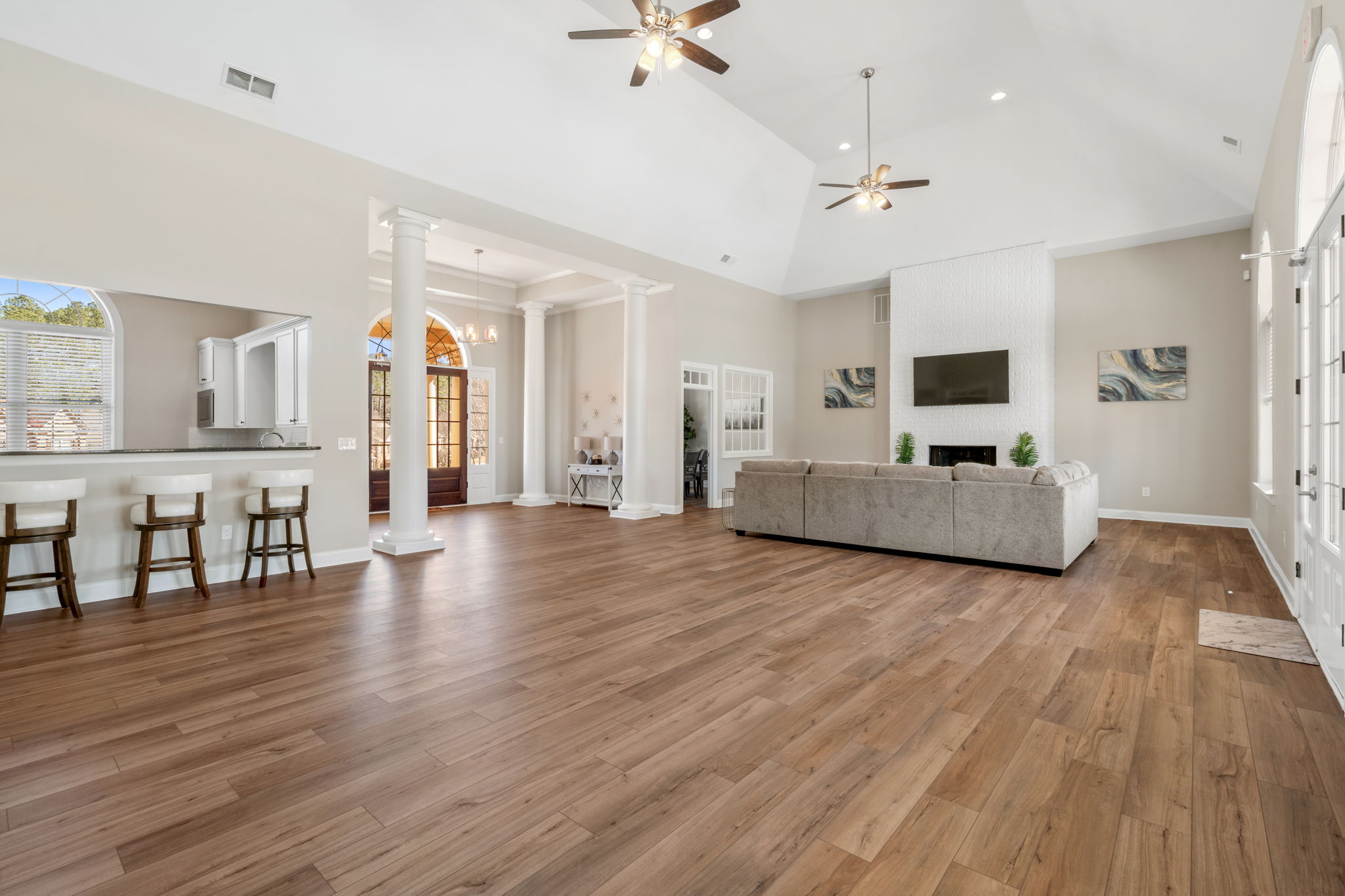A large living room with a wood floor.