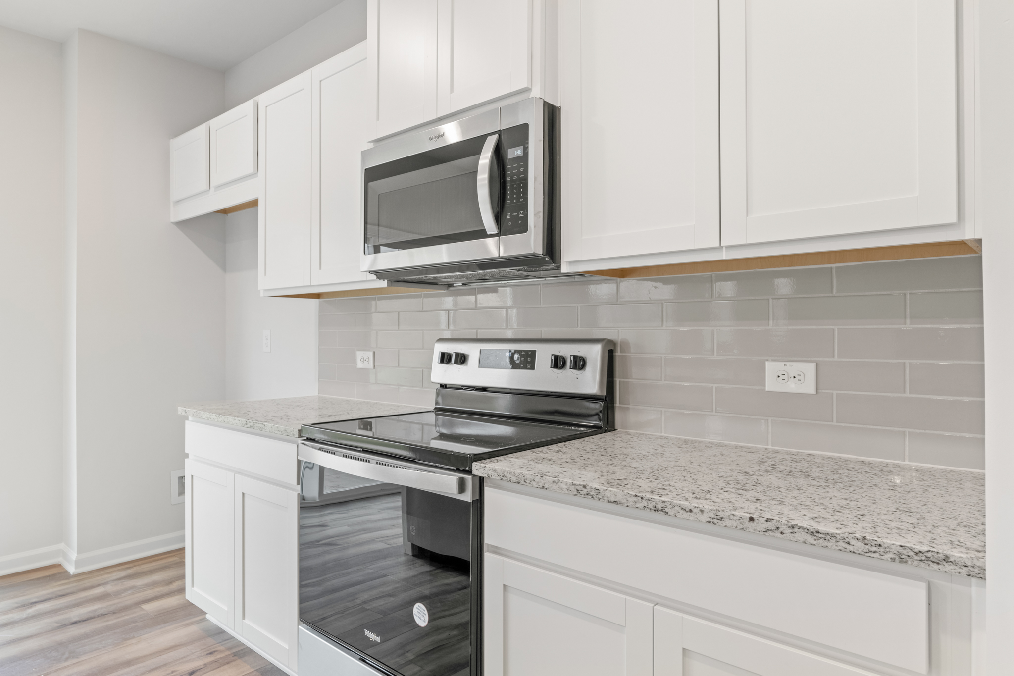 A kitchen with white cabinets.
