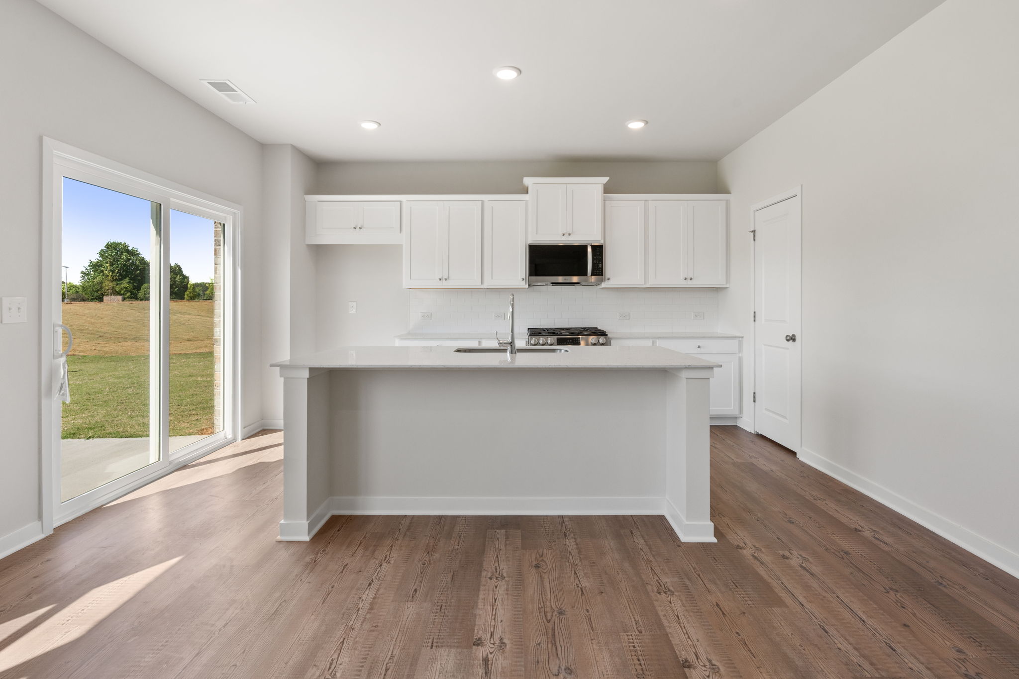 A kitchen with white cabinets.
