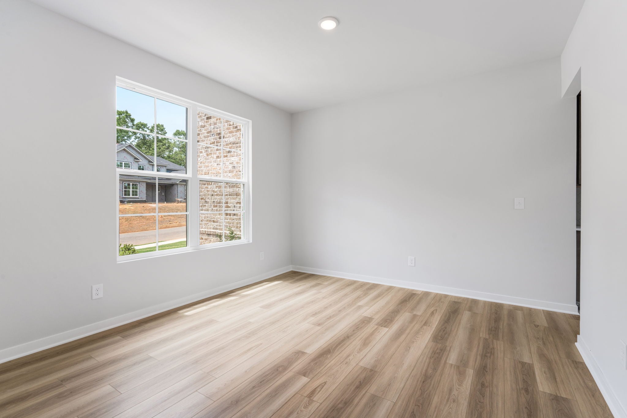 A room with a wood floor and a window with a wood floor.