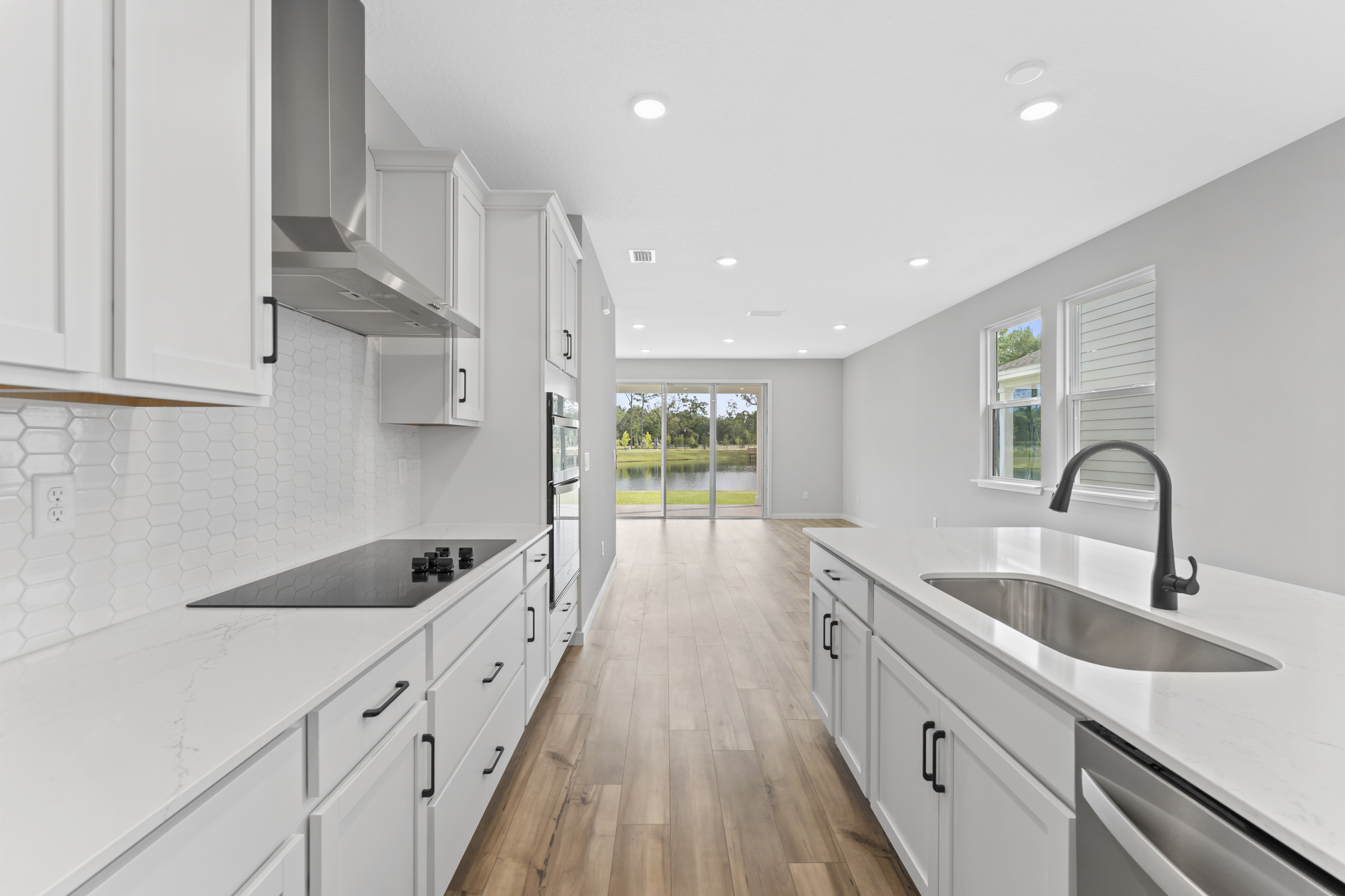 Miramar Floorplan Lot 81 Kitchen with White Cabinets and Black Hardware at Concourse Crossing in Fernandina Beach