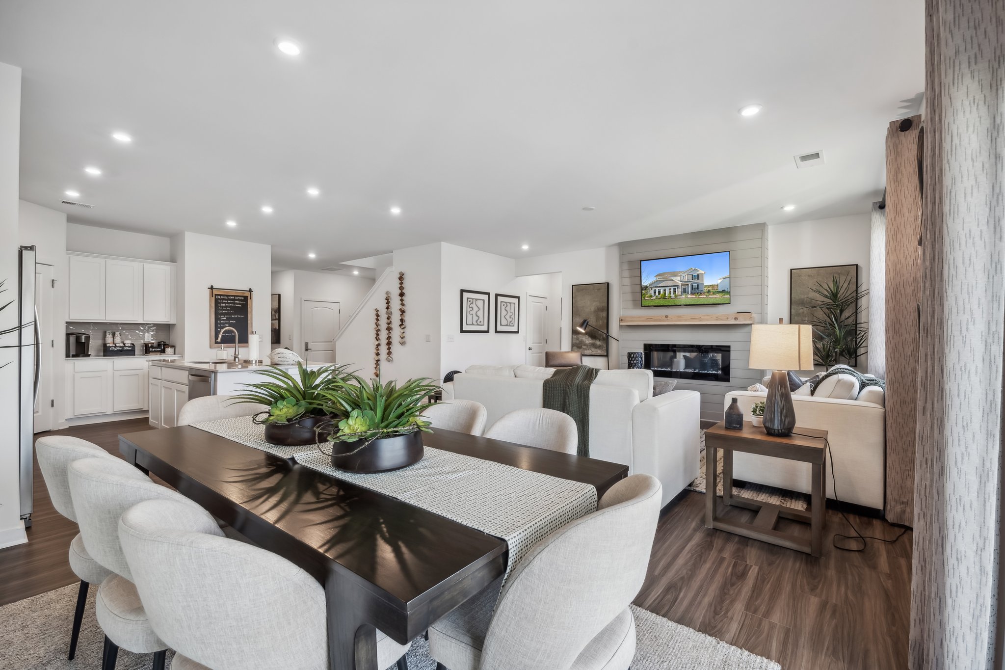A living room with a large table and chairs.
