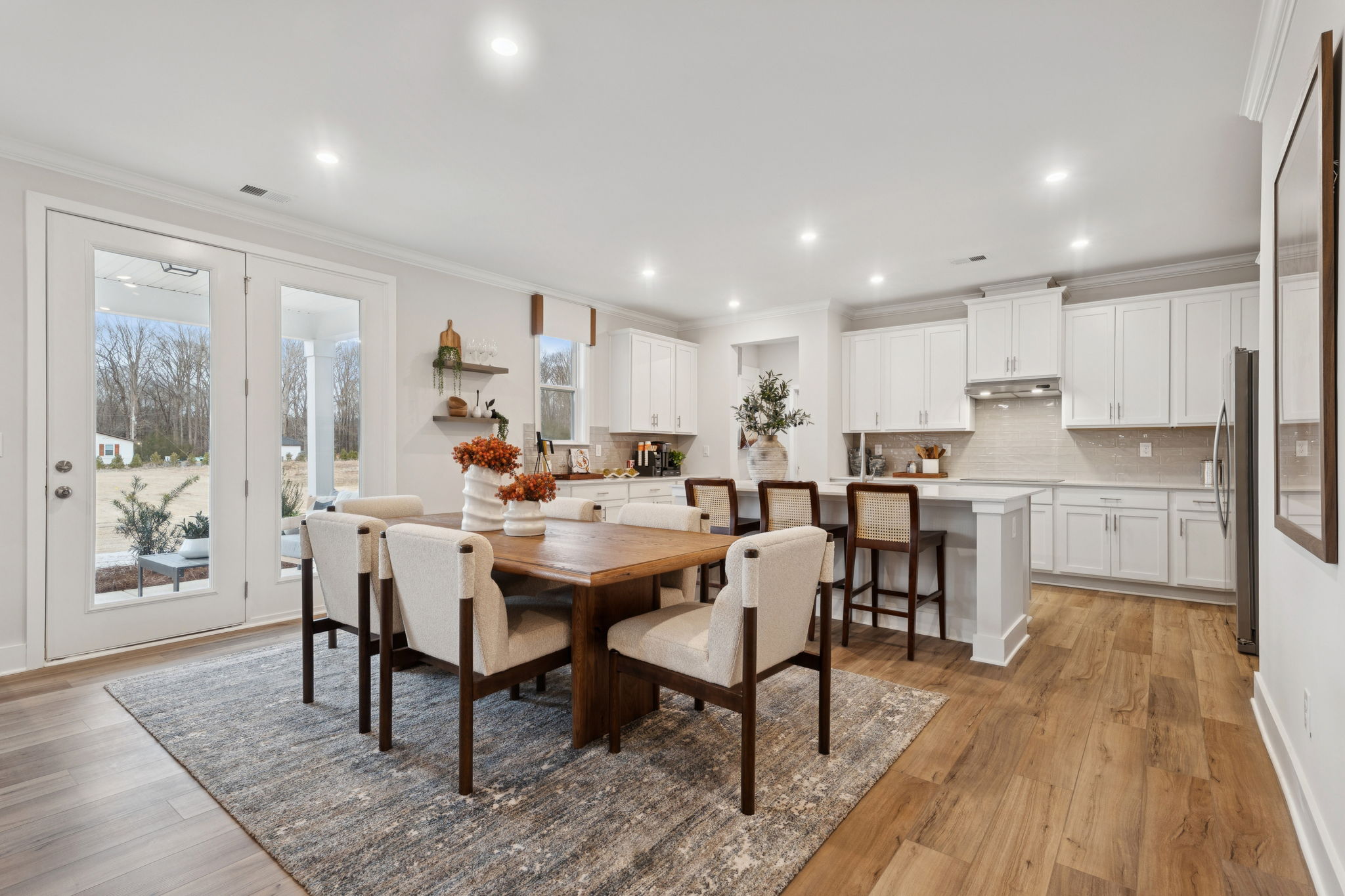 A kitchen with a dining table and chairs.