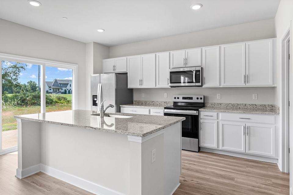 A kitchen with white cabinets.