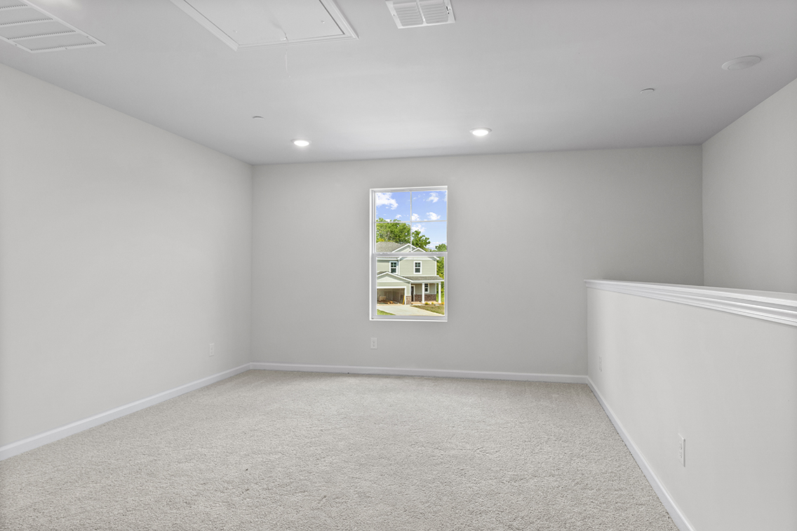 A room with a window and a white wall.