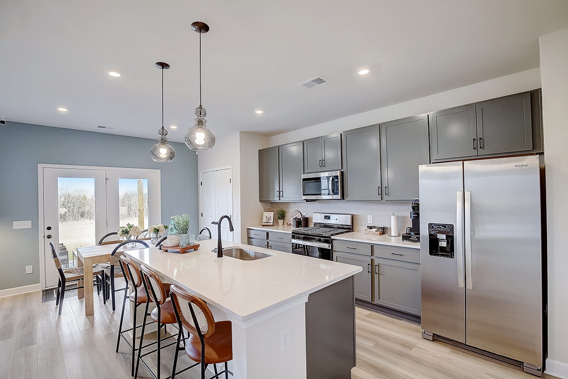 A kitchen with a white table and a white refrigerator.